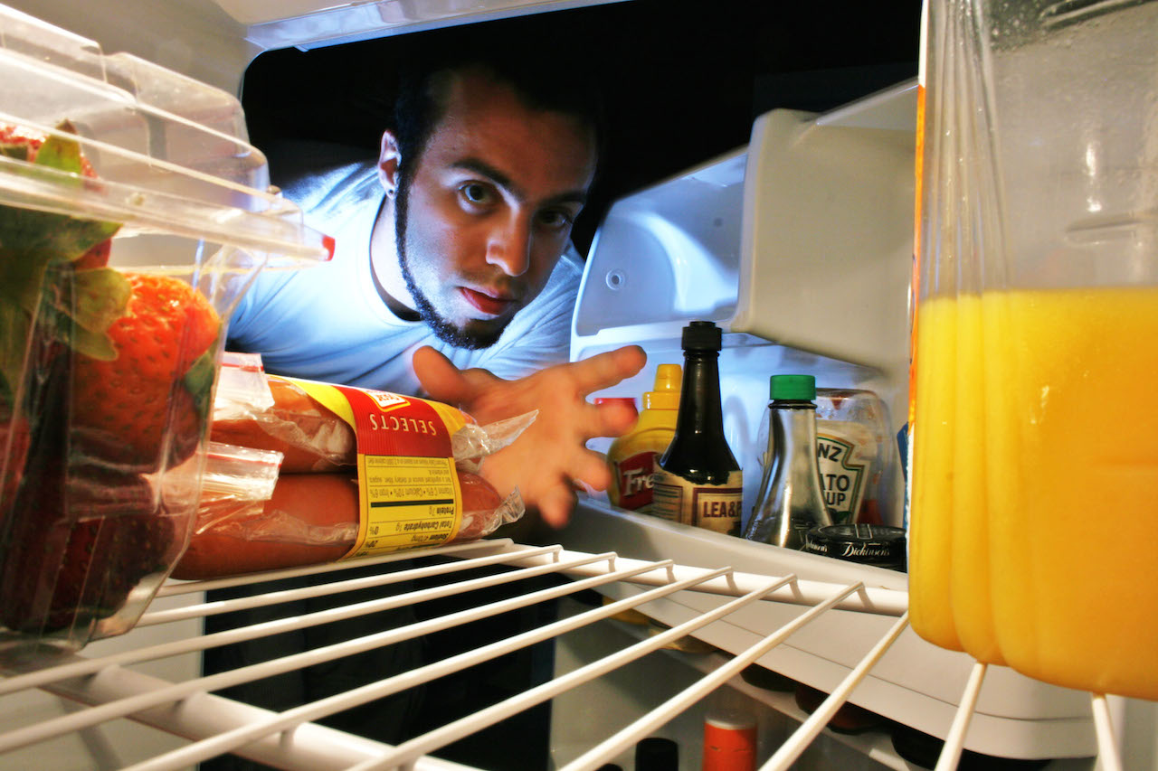 冷蔵庫をあさる夜間摂食症候群の男性